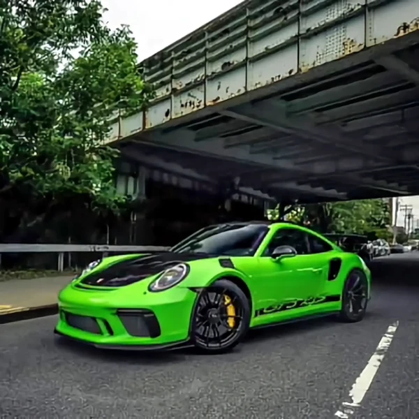 Porsche 911 steht unter einer Brücke, das Fahrzeug ist in giftgrüner und schwarzer Farbe foliert